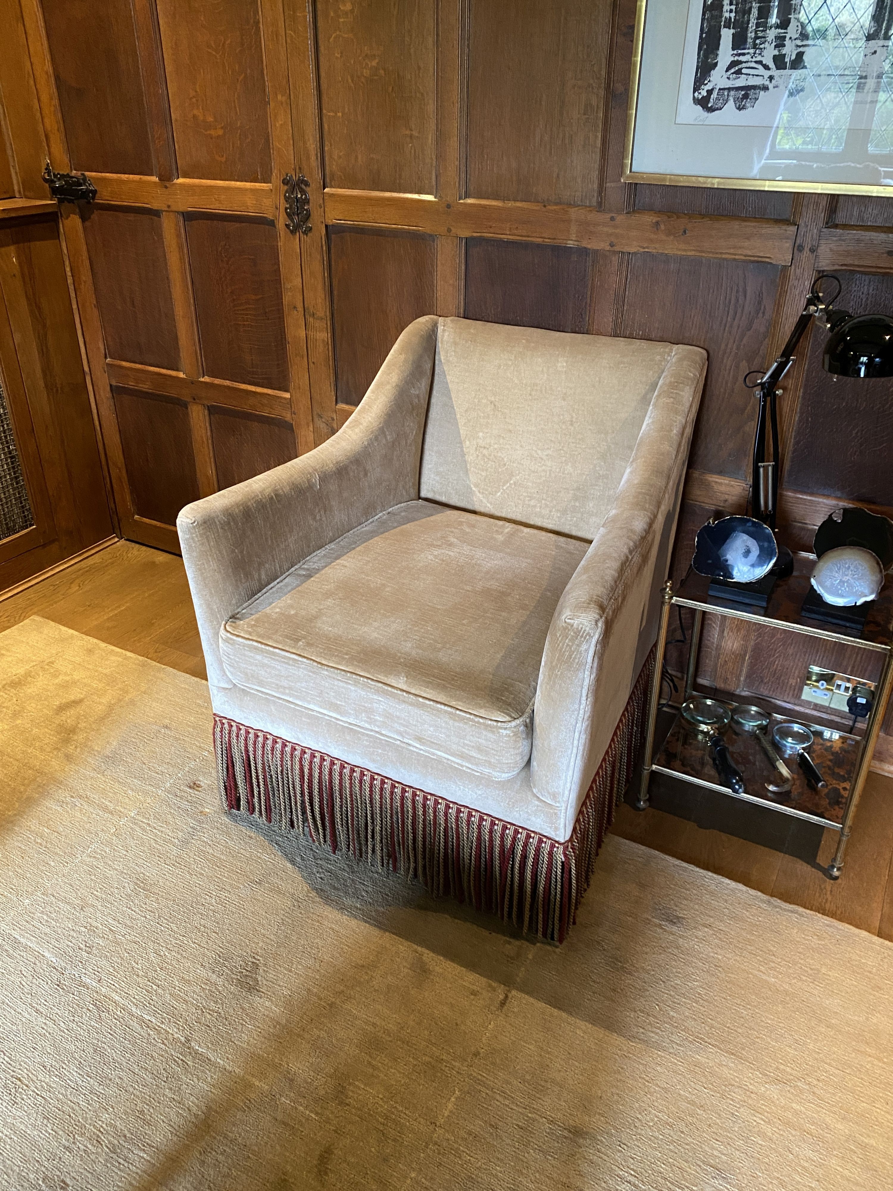 A pair of pale beige chenille armchairs, with tassle fringes, width 77cm depth 80cm